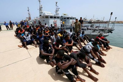 Un groupe de migrants sur une base militaire après avoir été secourus par les gardes-côtes libyens, à Tripoli, le 3 juillet 2018. ISMAIL ZITOUNY / REUTERS