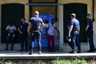 Des CRS contrôlent des migrants, à la gare de Menton, près de la frontière franco-italienne, le 14 juin. MIGUEL MEDINA / AFP