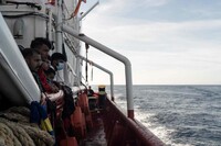 Des migrants regardent un patrouilleur des garde-côtes françaises s’approcher de l’Ocean Viking, le 10 novembre 2022. VINCENZO CIRCOSTA / AFP