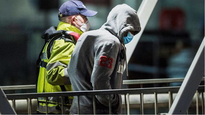 Un migrant accompagné d'un agent britannique à Douvres, après avoir traversé la Manche. Crédit : Picture alliance