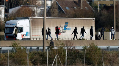 Des migrants près de l'autoroute qui mène au tunnel sous la Manche. Crédit : Reuters