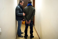 Un policier de l'OCRIEST avec un suspect lors d'une perquisition dans un appartement à Viry-Chatillon, le 3 mars 2014. © Photo Martin Bureau / AFP
