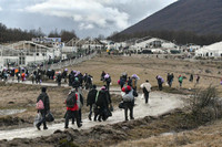 Des migrants retournent à pied au camp incendié de Lipa, près de Bihac (Bosnie), mercredi 30 décembre 2020. Des centaines d’entre eux devaient être transférés mardi vers un nouveau site dans le centre du pays, mais ils ont passé vingt-quatre heures dans des bus avant de se voir ordonner de retourner au camp, désormais vide. Kemal Softic / AP
