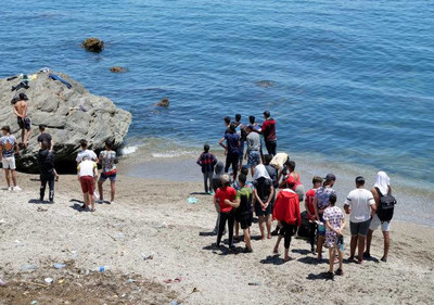 Des migrants sur la plage de Fnideq, près de l’enclave espagnole de Ceuta, au Maroc, le 19 mai 2021. SHEREEN TALAAT / REUTERS