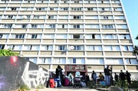 Des habitants au pied d’un immeuble squatté du parc Kallisté évacué par des policiers et des CRS, à Marseille, le 10 mai 2022. CHRISTOPHE SIMON / AFP