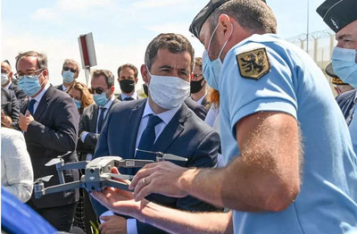  Gérald Darmanin lors d'un autre déplacement à Calais, en juin 2020, observe l'un des drones de la police. • © DENIS CHARLET / AFP