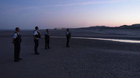 Une patrouille de policiers sur la plage de la Slack, vers 6h30 le 8 septembre. Crédit : Mehdi Chebil pour InfoMigrants