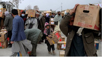 Des Afghans récupèrent des colis d'aide alimentaire distribués par une ONG turque, le 15 décembre 2021, à Kaboul. Crédit : Reuters