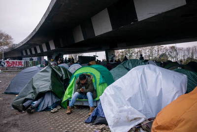 Un migrant afghan à l’intérieur d’un campement de fortune aux abords du Stade de France, le 2 novembre. Benjamin Girette pour "Le Monde"