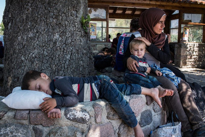 Une Maman réfugiée et ses deux enfants se reposent après leur arrivée par bateau sur l’île de Lesbos, en Grèce.  © HCR/A.McConnell