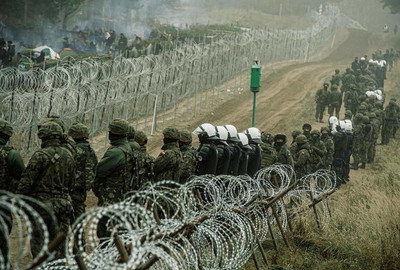 Des soldats et des policiers polonais surveillent, le 12 novembre 2021 près de Kuznica, la frontière avec la Biélorussie, où des milliers de migrants sont massés. HANDOUT / VIA REUTERS