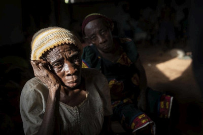 Une femme âgée est assise dans une salle où des réfugiés anglophones du Cameroun attendent d’être relocalisés dans le camp de réfugiés d’Agadom à Ogoja, au Nigeria, en avril 2019.   © HCR / Will Swanson