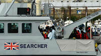  Des migrants se rassemblent, amenés au port par la UK Border Force après avoir été récupérés en traversant la Manche depuis la France, le 14 avril 2022, dans la marina de Douvres, sur la côte sud-est de l'Angleterre. AFP - GLYN KIRK 