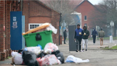 Des migrants marchent dans l'enceinte de la caserne Napier à Folkestone, dans le Kent, en Angleterre, à la suite d'un incendie sur le site, le dimanche 31 janvier 2021. Crédit : AP 