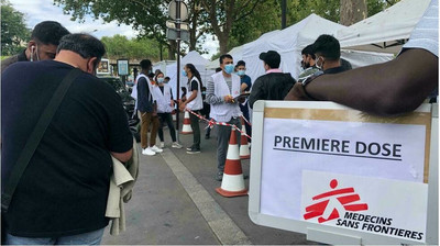  Porte de la Villette, à Paris 19e, des personnes migrantes et sans-abri font la queue pour se faire vacciner contre le Covid-19 dans la clinique mobile de Médecins sans Frontières. © Lou Roméo / RFI 