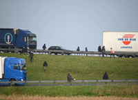 Des migrants essayent de monter à bord de camions stationnés à l’entrée du tunnel sous la Manche, le 17 décembre 2020. DENIS CHARLET / AFP